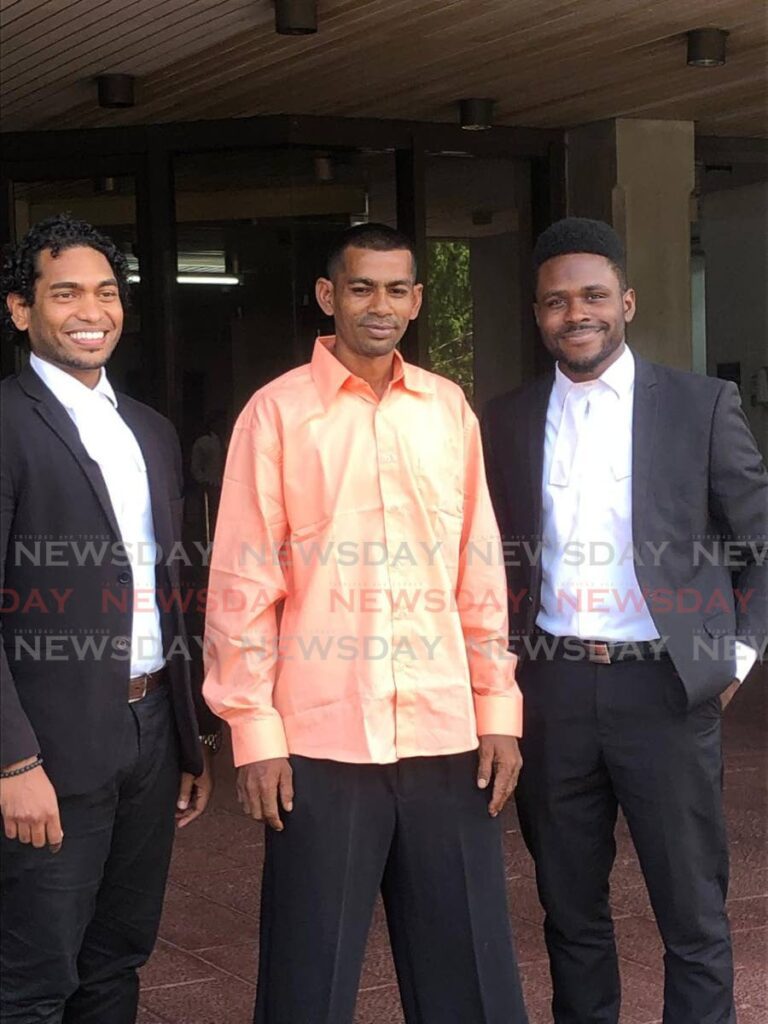 Kevin Madoo, centre, stands with his attorneys Shaun Morris, left, and Michael Modeste, right, outside the Hall of Justice, Port of Spain, on May 21, after he was acquitted by a High Court judge of an attempted murder charge. - Photo by Jada Loutoo