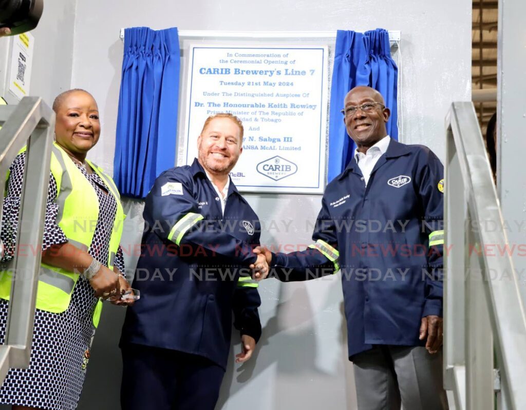 Ansa McAl Group CEO Anthony Sabga III, left, shakes hands with Prime Minister Dr Keith Rowley, after unveiling a plaque at the ribbon-cutting ceremony for Carib’s new manufacturing Line 7 at Carib Brewery, Champs Fleurs, on May 21.  - Photo by Ayanna Kinsale