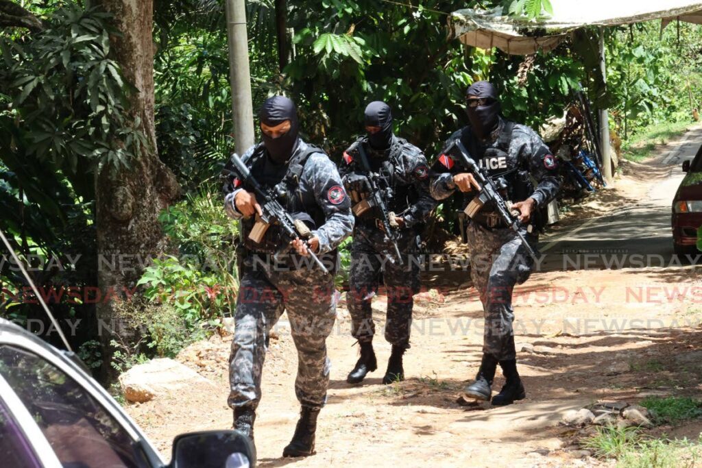 Police officers assigned to a specilised unit who were part of an operation on May 23 where four members of the Resistance gang were killed in what police claimed to be a firefight in the hills of Upper St Michael Road, off St John's Road, St Augustine. - Photo by Roger Jacob