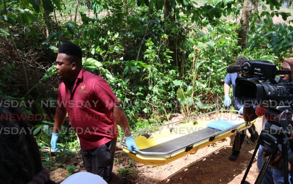 DEAD END: Funeral agency workers carry a gurney to the area in the forest off St Michael's Road off St John's Road in St Augustine on Thursday after four men were killed in a police-involved shooting. PHOTO BY ROGER JACOB - ROGER JACOB