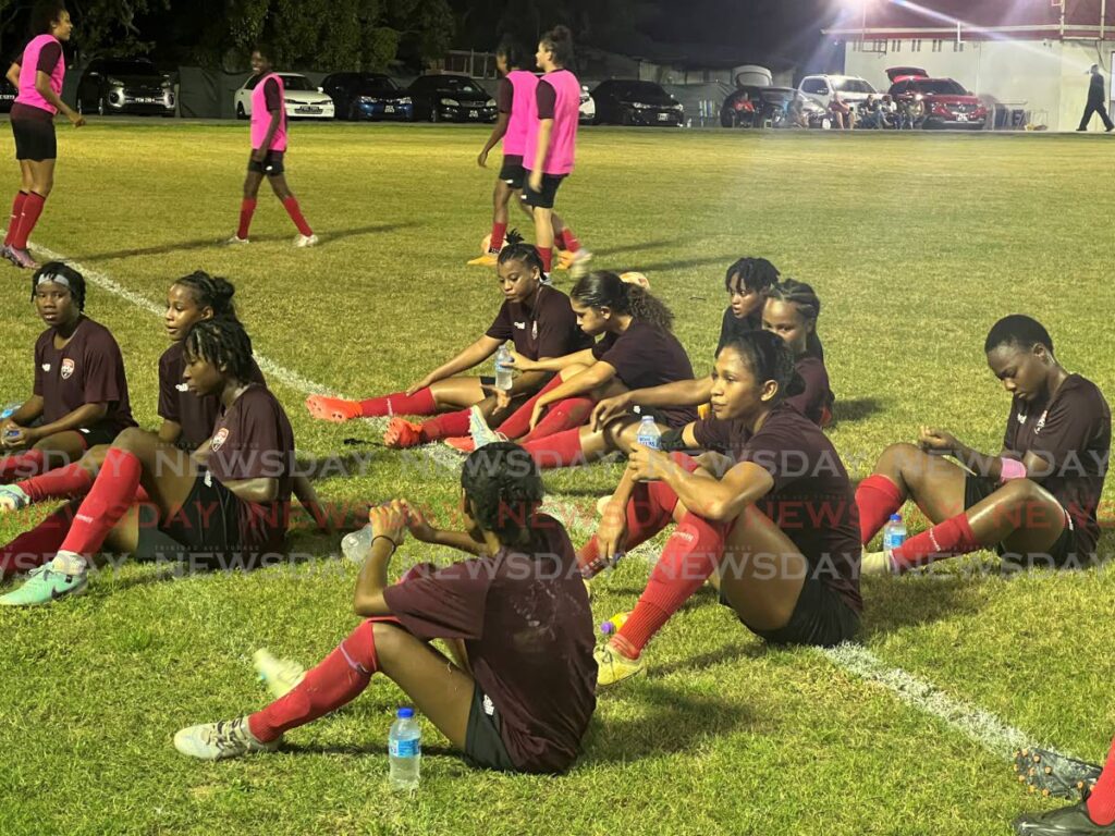 Members of the TT women's football team sit at half-time during a warm-up game against Club Sando women at the La Horquetta Recreation Ground on May 23. - Enrique  Rupert