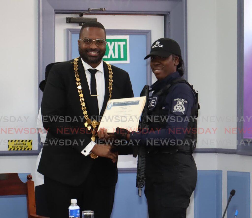 Port of Spain Mayor Chinua Alleyne presents a certificate of commendation to WPC Smith at the end of the monthly statutory meeting in City Hall, Knox Street, Port of Spain on May 28.