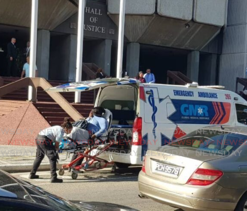 A state witness is placed in an ambulance outside the Hall of Justice, Port of Spain on May 22. - Photo by Jada Loutoo