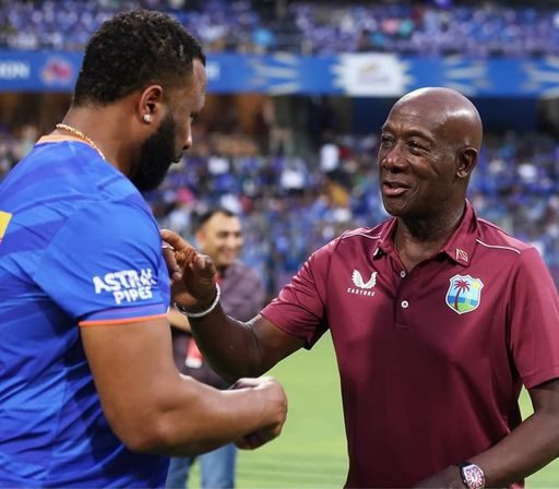 Prime Minister Dr Keith Rowley, right, greets former West Indies T20 captain and Mumbai Indians assistant coach Kieron Pollard at the start of the Indian Premier League match against Lucknow Super Giants on May 17 in Mumbai. Photo courtesy Dr Keith Rowley's Facebook Page
