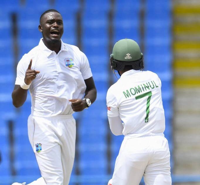 In this June 22, 2022 file photo, West Indies' Jayden Seales (L) celebrates the dismissal of Mominul Haque (R) of Bangladesh during the first day of the first Test at the Sir Vivian Richards Cricket Stadium in North Sound, Antigua. - 