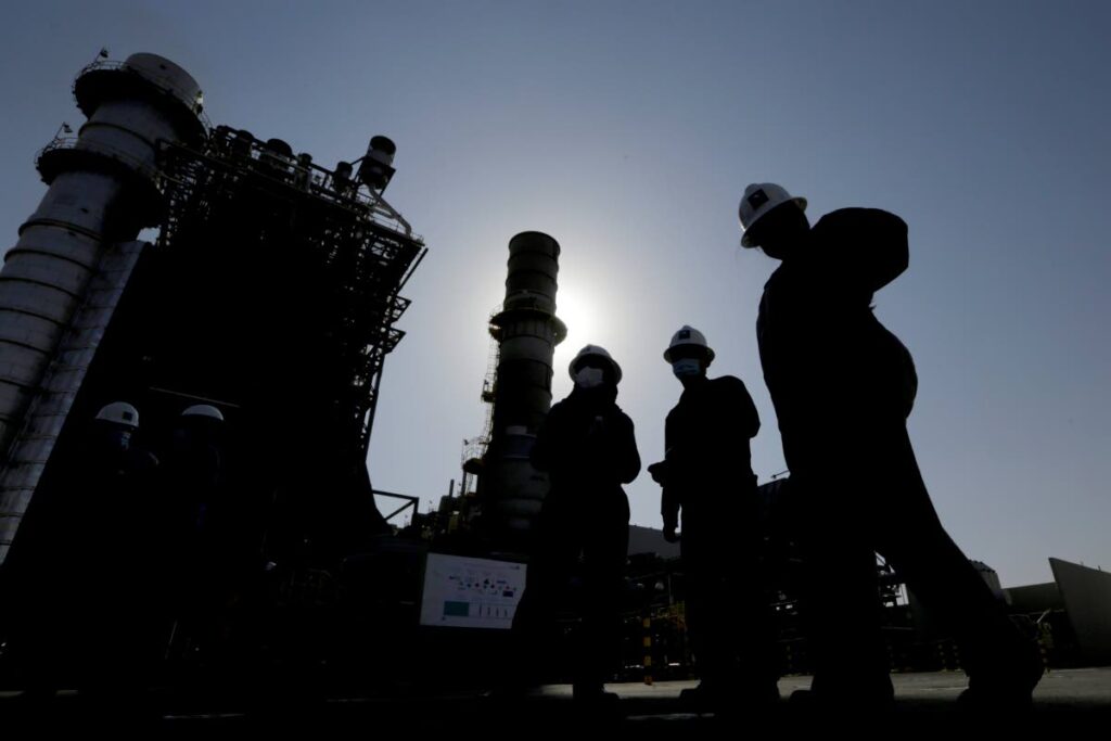 Saudi Aramco engineers walk in front of a gas turbine generator at Khurais oil field during a tour for journalists as Saudi Arabia announced Sunday it will cut oil production by 500,000 barrels per day from May until the end of 2023. It was joined by several major oil producing countries AP PHOTO - 