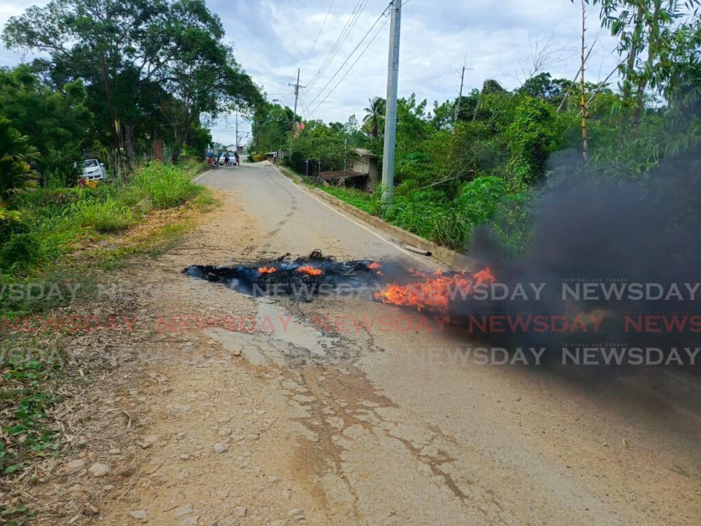 Burning debris at the scene of a protest staged by Whiteland residents on Corosal Road on June 3. -