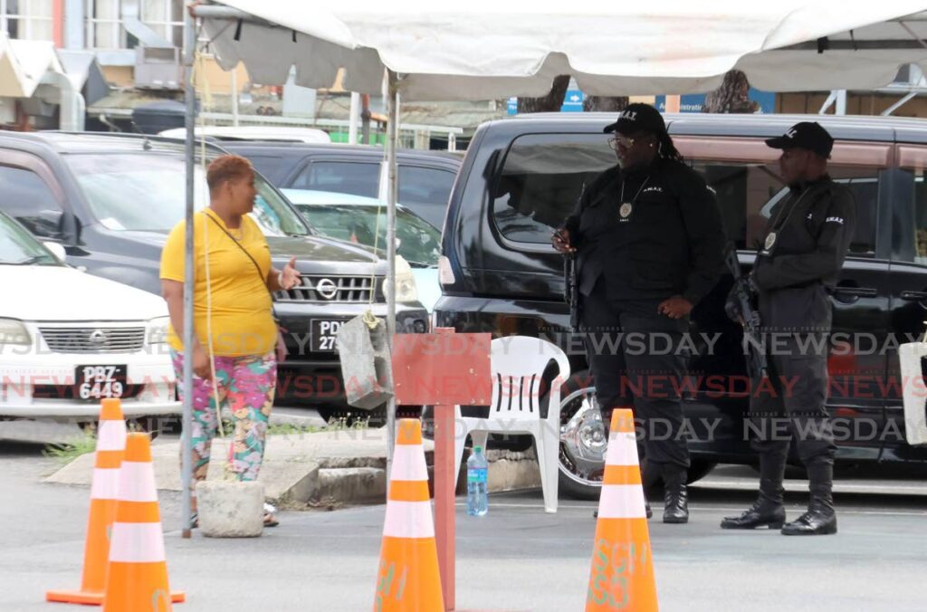 A woman speaks with security guards at the Port of Spain General Hospital on June 3, hours after three men were gunned down at the hospital’s Accident and Emergency department. - Photo by Roger Jacob