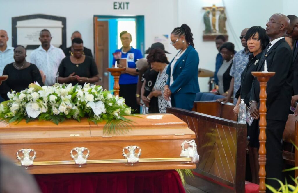 GOODBYE BRO: The Prime Minister, right, prays during the funeral for his brother Felix Joseph at the St Andrew’s Anglican Church in Scarborough, Tobago on Thursday.  - Photo by Caswell Gordon