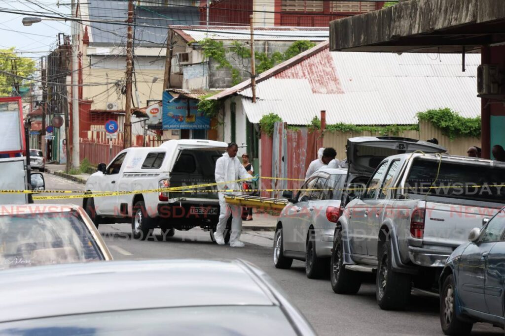 Crime scene investigators at the scene of a murder along Nelson Street, Port of Spain on June 9. - Photo by Roger Jacob 