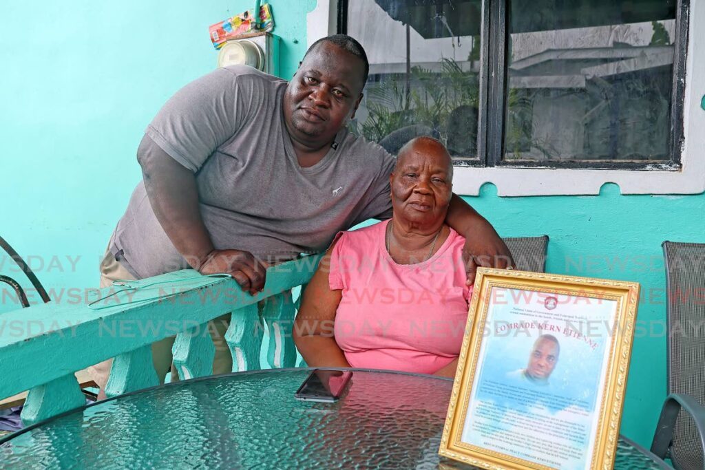 Kerdell Etienne, twin of WASA worker Kern Etienne, who died in a work-site accident, hugs his mother Joyce Grant-Roberts on Sunday at their Embacadere home, San Fernando. - Photo by Lincoln Holder