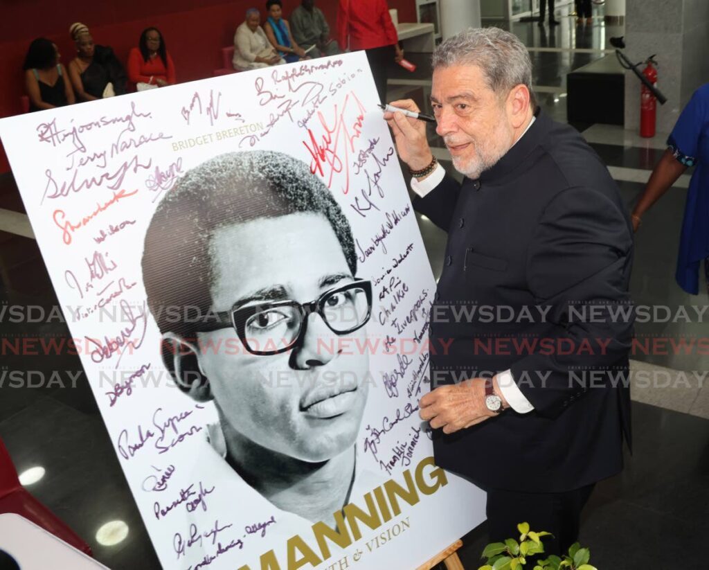 St Vincent and Grenadines Prime Minister Dr Ralph Gonsalves signs a poster at the launch of Manning: Faith & Vision, a biography of former prime minister Patrick Manning, at NAPA, Port of Spain on June 9. - Photo by Roger Jacob