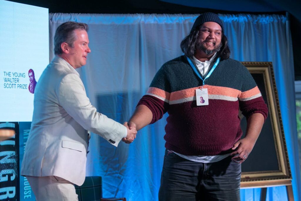 Kevin Jared Hosein, right, receives his prize on from the great-great-great-great grandson of Walter Scott, Matthew Maxwell Scott at Abbotsford on June 13.   - Photo courtesy Lloyd Smith