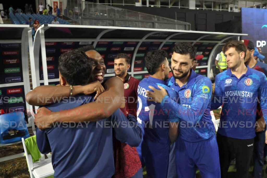 West Indies T20 legend Dwayne Bravo, second from left, hugs a member of the Afghanistan staff after the team booked their spot in the World Cup Super 8 on June 13. - Photo by Roger Jacob