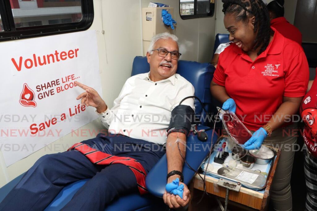 Health Minister Terrence Deyalsingh donates blood on June 14, World Blood Donor Day, in a mobile unit located at the Brian Lara Promenade in Port of Spain. - Photo by Angelo Marcelle