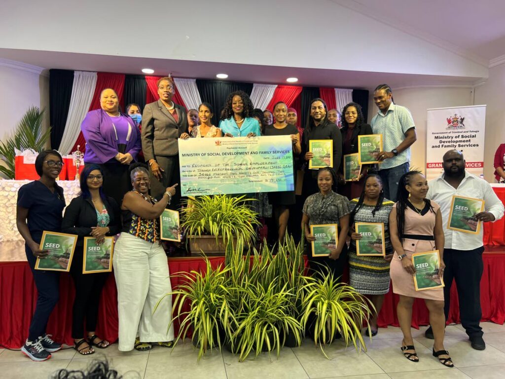 Minister of Social Development and Family Services Donna Cox (centre) holds the cheque for the recipients of the SEED programme at the distribution ceremony held on June 17 at the Diego Martin Community Centre, Diamond Vale. - Photo by Enrique Rupert