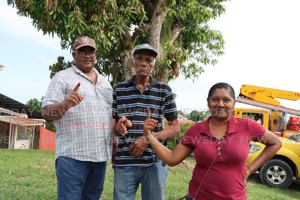 From left, Keith Roopnarine, Deonarine Roopnarine, and Yukti Cindy Roopnarine show their fingers after voting at the St Croix Community Centre, during the local government by-elections on June 17. - Photo by Ayanna Kinsale