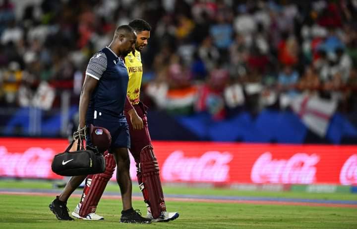 West Indies opening batsman Brandon King, right, is helped off the field after suffering a side strain in his team's ICC T20 World Cup Super Eight clash with England at the Daren Sammy Cricket Ground in St Lucia on June 19. - Photo courtesy Windies Cricket.