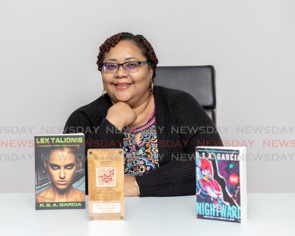 Author Rhonda Garcia shows off her books on June 21 at Newsday's Pembroke Street, Port of Spain office. - Photo by Jeff K. Mayers