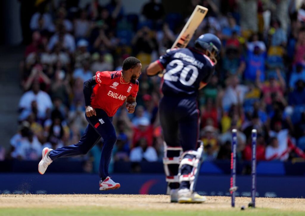 England’s Chris Jordan, left, celebrates after getting a hat-trick by dismissing United States’ Saurabh Nethralvakar, right, during the ICC Men’s T20 World Cup at Kensington Oval in Bridgetown, Barbados, Sunday. - AP