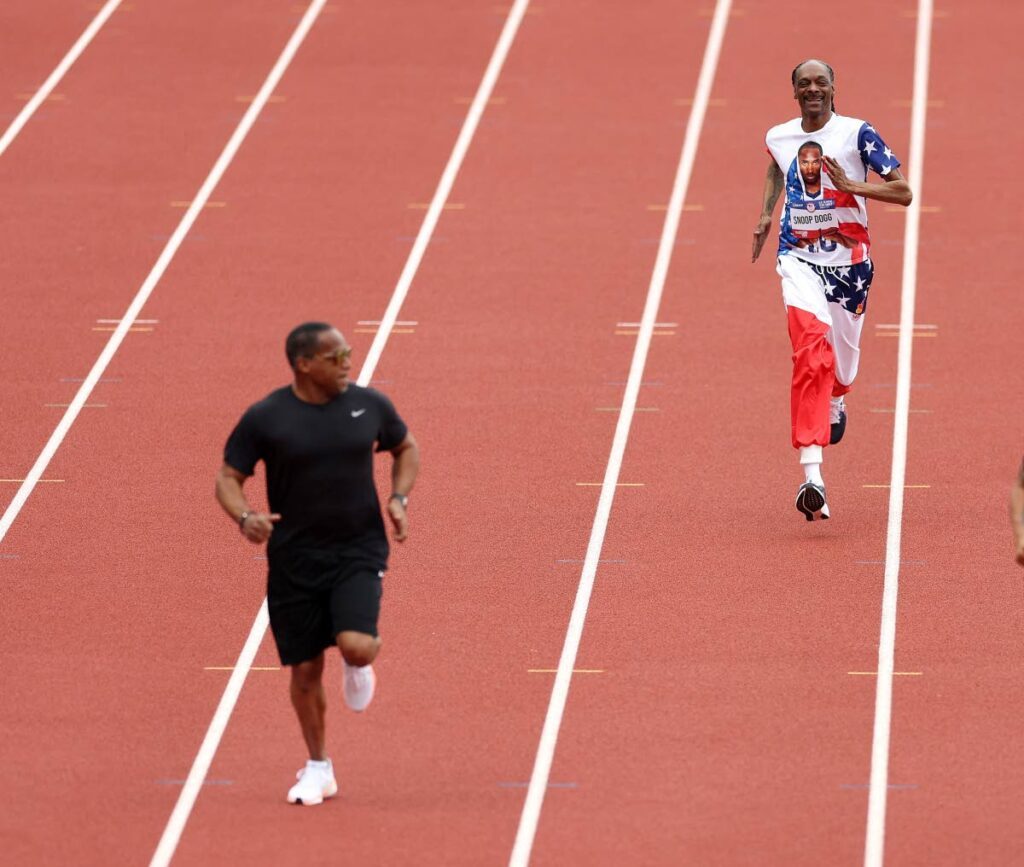 Former Trinidad and Tobago sprinter Ato Boldon, left, looks back at the trailing Snoop Dogg during a 200m exhibition race at the US Olympic Trials, at Hayward Field, Eugene, Oregon, June 23. - 