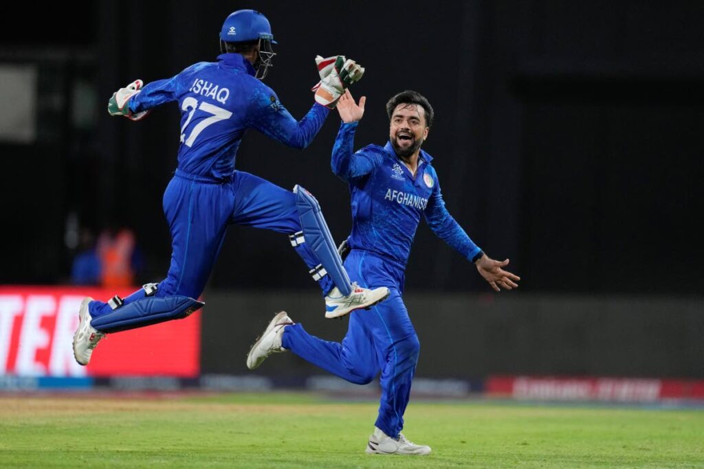 Afghanistan's captain Rashid Khan, right, is congratulated by teammate Mohammad Ishaq after dismissing Bangladesh's Rishad Hossain during the men's T20 World Cup at Arnos Vale Ground, Kingstown, Saint Vincent and the Grenadines, June 24. - AP