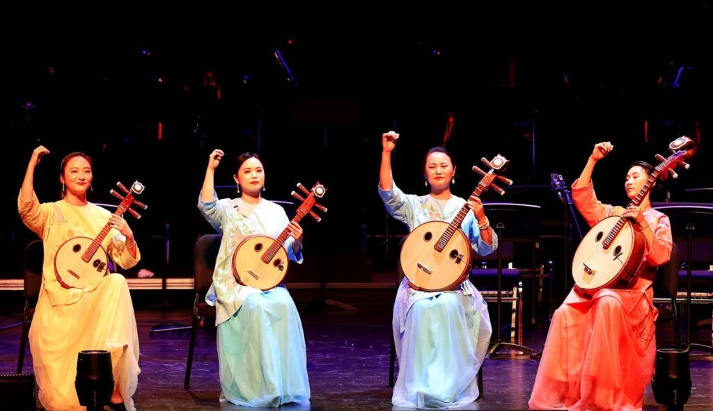 Women of the Shanghai Chinese Orchestra play the rhuan instrument during the commemorative concert. - Andrea De Silva