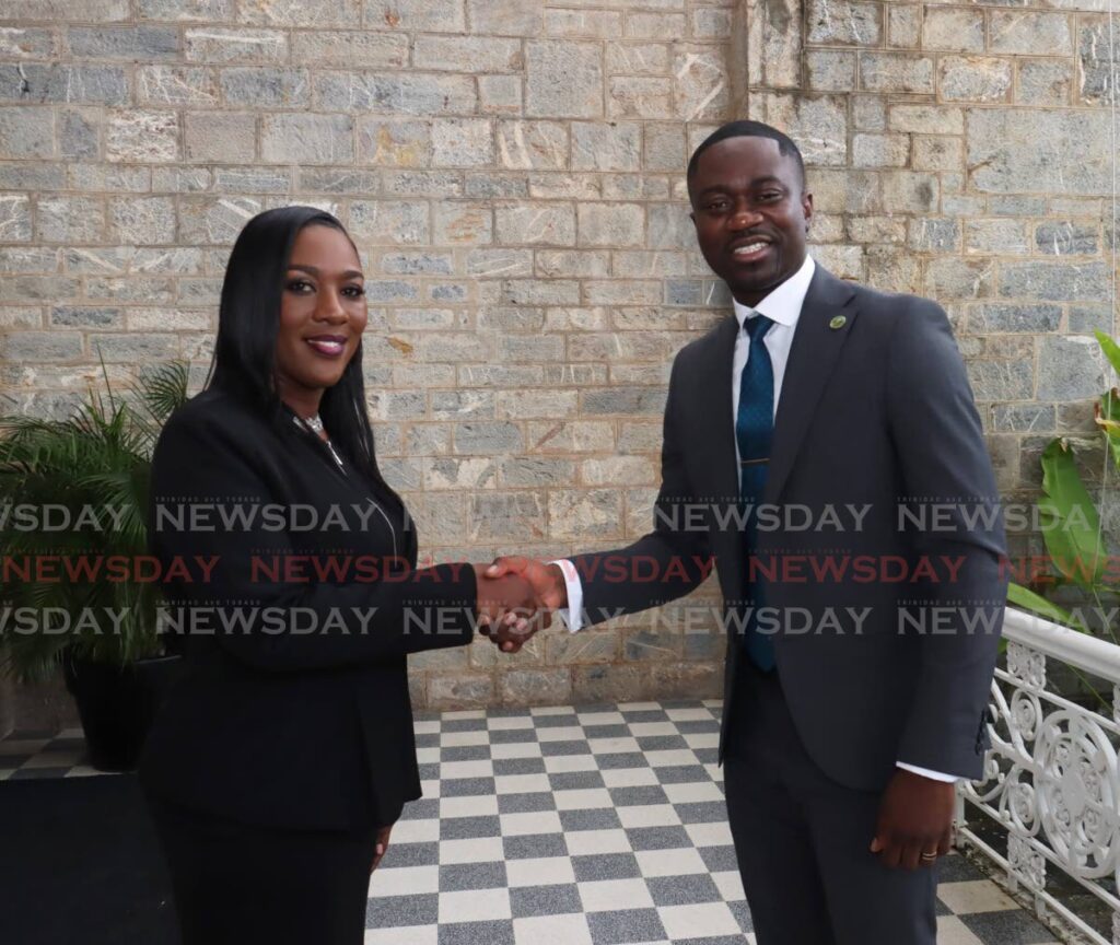 Petal-Ann Roberts, THA Secretary of Finance, left, shakes hands with THA Chief Secretary Farely Augustine, after being sworn in at the President's House, Queen's Park Savannah, on June 28.   - Photo by Faith Ayoung