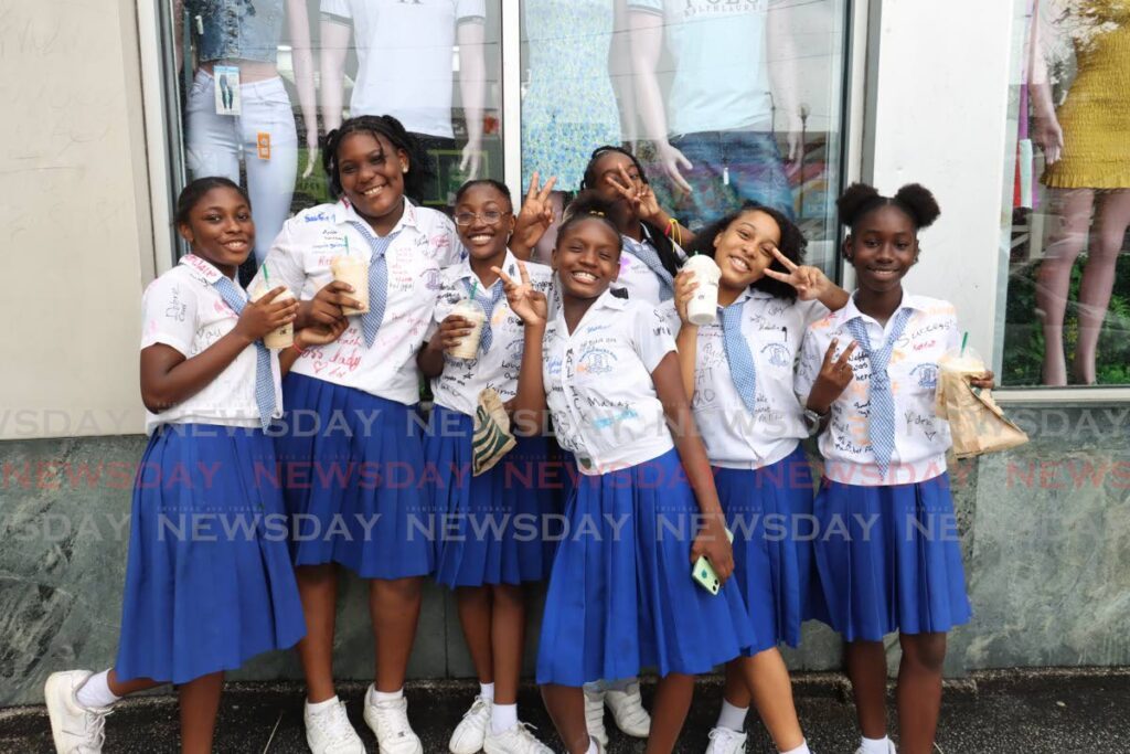 BRIGHT GIRLS: A group of girls from Nelson Street Girls' RC School celebrates with bright smiles and drinks from Starbucks on Independence Square, Port of Spain, after receiving their SEA results on June 28. - Photo by Faith Ayoung