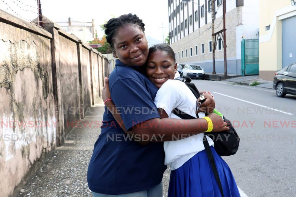 Nelson Street Girls' RC student Kedeshia Best-Wilson gets a hug from her sister-in-law Annella Adonis outside the school at Nelson Street, Port of Spain, on June 28.
Editor's note: She was on her way to collect the slip to access her results. - Faith Ayoung