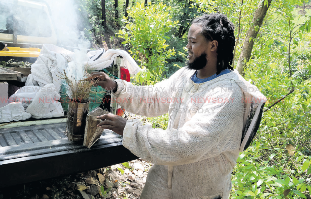 Khafre Pilgrim prepares a smoker before going to his hives at his Five Rivers, Arouca farm. PHOTO BY ROGER JACOB