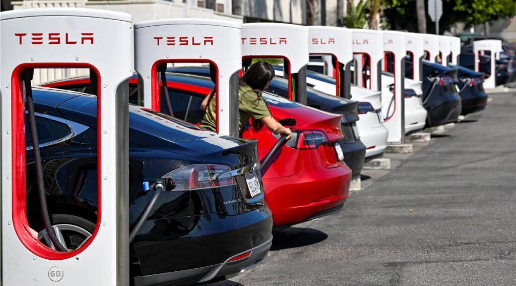 CHARGING: Drivers charge their Tesla electric vehicles in Santa Ana, California. AP PHOTO - 