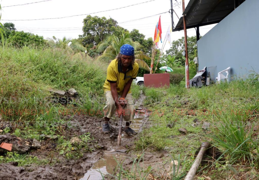 Anand Boodram clears a drain in anticipation of flooding that could be caused by rains associated with the passage of Hurricane Beryl at Bamboo No 2, Valsayn, on July 1. - Photo by Ayanna Kinsale