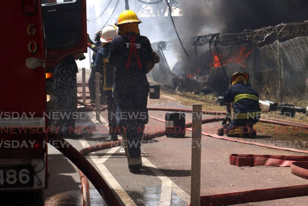 A leak in one of the hose can be seen near the firetruck as fireofficers set up the lines to out a fire at the compound of Caridoc, Western Main Road, Chaguramas, July 5.