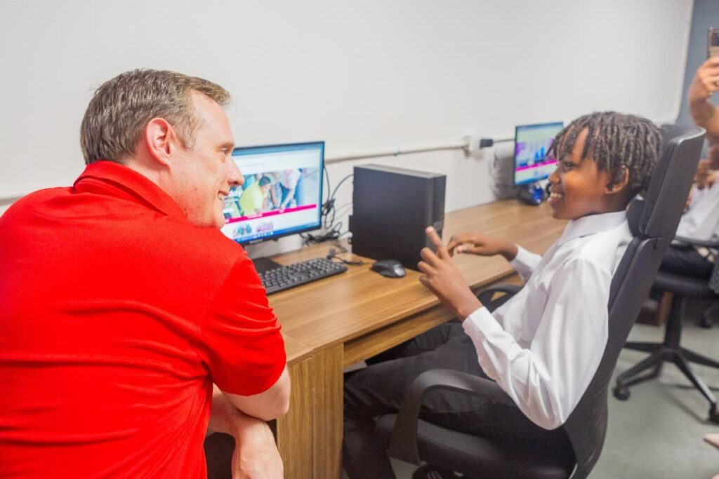 Abraham Smith, CEO of Digicel Trinidad and Tobago and board director of the Digicel Foundation, chats with a young pannist at the launch of the Technology in Education Centre at Pandemonium panyard, Belmont on February 28. - 