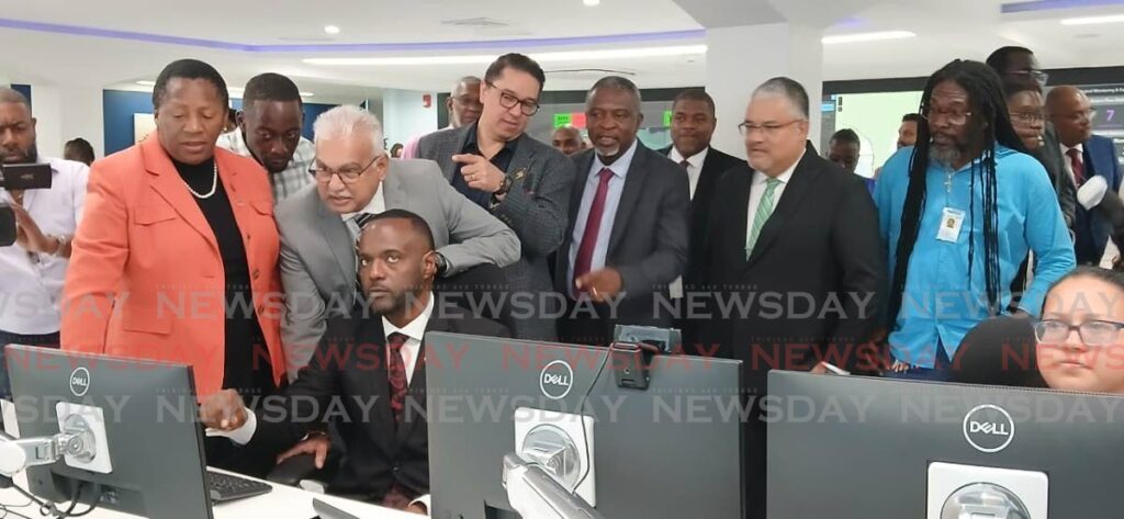 Minister of Public Utilities Marvin Gonzales (seated), operates a computer at WASA's Operational Control Centre on July 10 at WASA, St Joseph, watched by, from left, Cabinet colleagues Pennelope Beckles-Robinson,  Kennedy Richards, Terrence Deyalsingh, Symon de Nobriga and Hassel Bacchus, plus WASA chairman Ravindra Nanga.  - Photo by Sean Douglas 