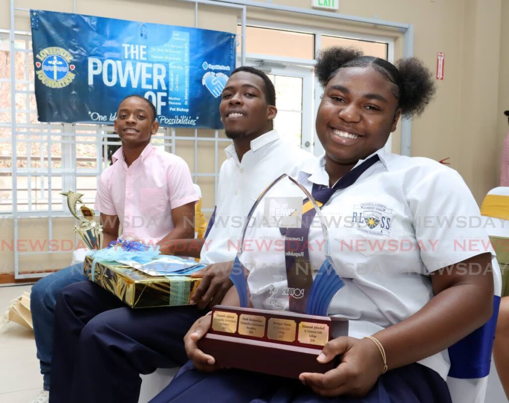 Russell Latapy Secondary School students, from left, Josiah Pesnel, Jeremiah Rodriguez and Juniah Victor Thomson are alll smiles after copping first place at the Republic Bank Loveuntil Foundation Power of One prize giving ceremony at Maitagual Community Centre, Petit Bourg, on July 11. The trio, all 17 years old, had to come up with a project/programme that will make a lasting impact in their school, community or the country at large. - Photo by Faith Ayoung