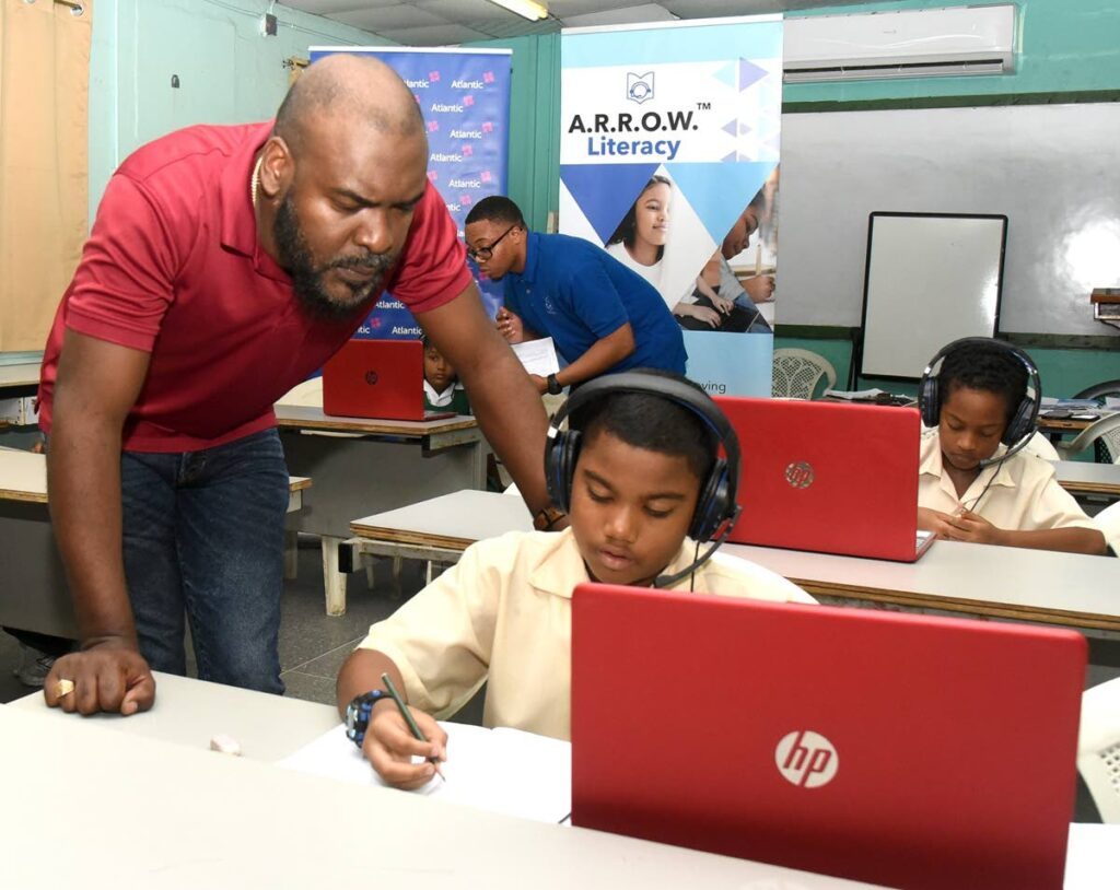 Ian Ochoa of Atlantic observes Point Fortin ASJA standard one student, Darien Williams, doing an Arrow literacy training session. - 