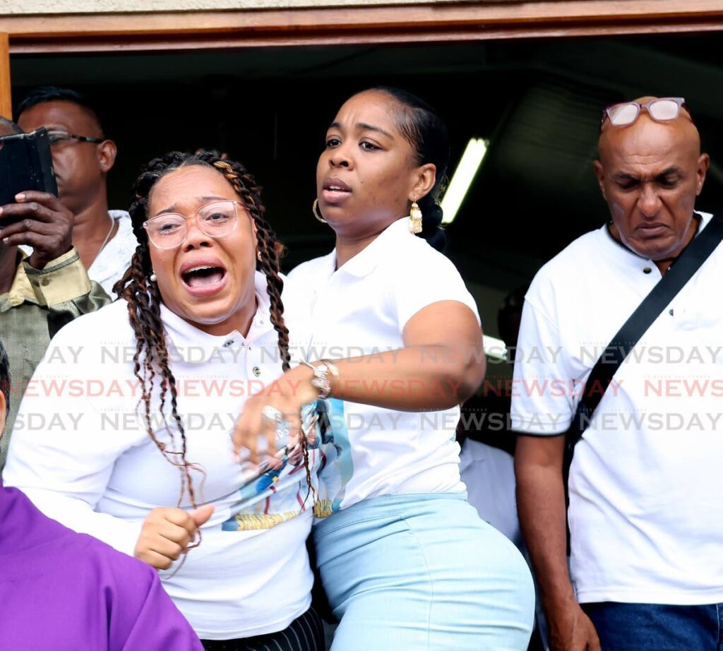 GRIEF-STRICKEN: Alyssa Elvin, left, mother of two children with murdered TT Rideshare driver Shakem Charles, had to be consoled at his funeral at the Our Lady of Mt Carmel RC Church in New Grant on Monday. Charles went missing on July 9 and his body was later discovered on July 13 in Penal. - Photo by Lincoln Holder 