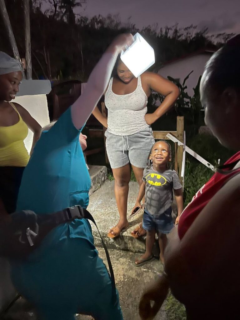 A Third Wave Volunteer team member shows off a solar light to residents of Carriacou - Photo courtesy Kiran Mathur Mohammed