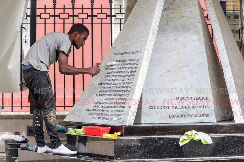 Orlando Boodram adds the finishing touches as he perfoms maintenance on the Cenotaph, a monument to those who lost their lives in the July 1990 attempted coup, at the Red House, Abercromby Street, Port of Spain on Tuesday. - Gabriel Williams