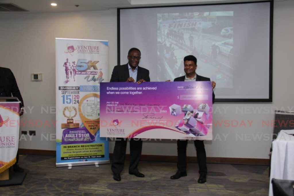 Board president of Venture Credit Union Charles Percy, left, and assistant secretary to the board and chairman of the 5K committee at Venture Credit Union Clint Mohan, receive a sponsorship cheque.  - 