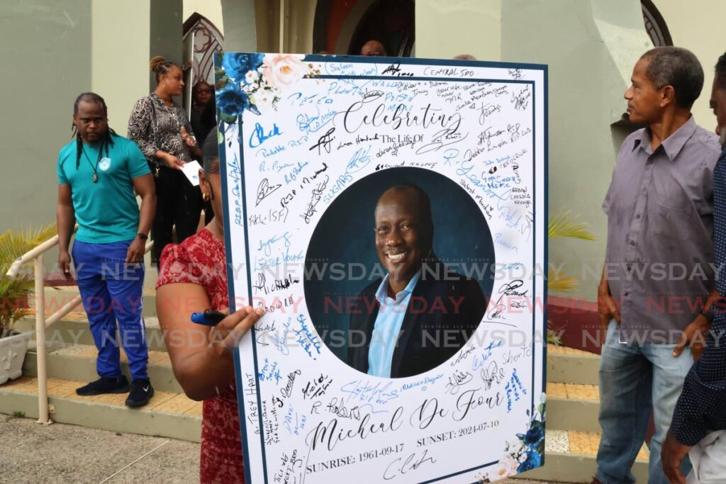 Family members, the football community and friends signed a memorial portrait of Michael De Four. - Photo by Roger Jacob