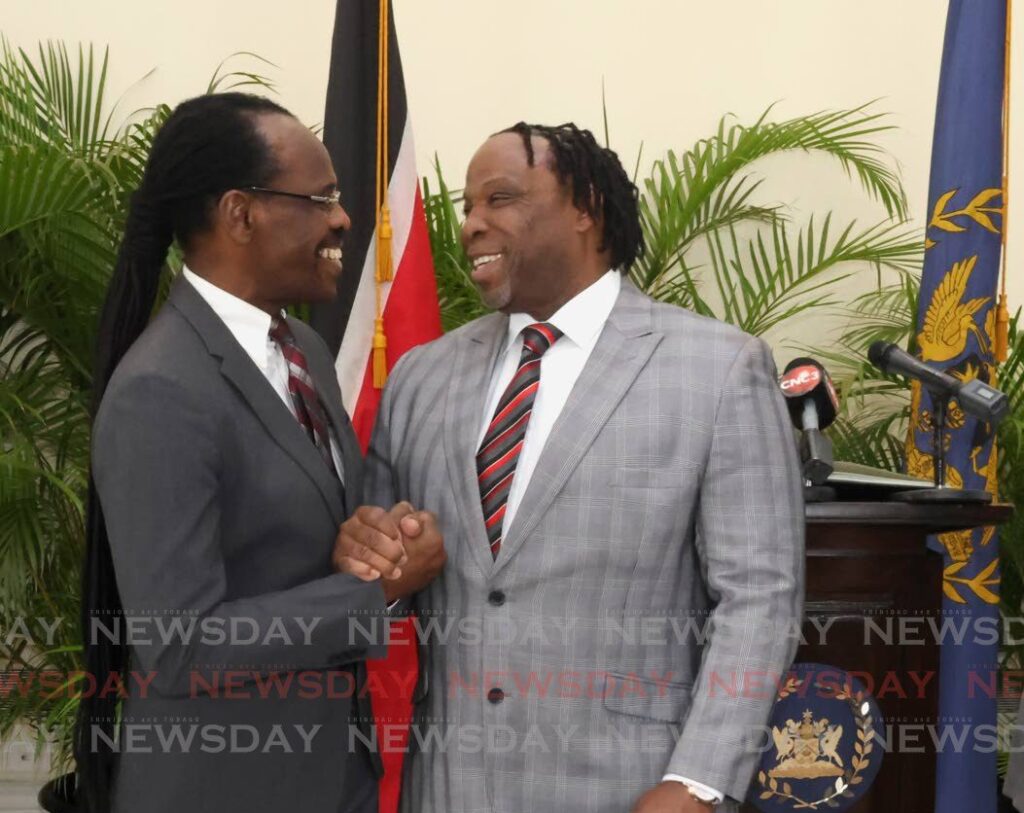 New Minister in the Ministry of National Security Keith Scotland, SC, right, is congratulated by National Security Minister Fitzgerald Hinds at Scotlands swearing-in ceremony at President's House, St Ann's on Friday. - Photo by Roger Jacob 