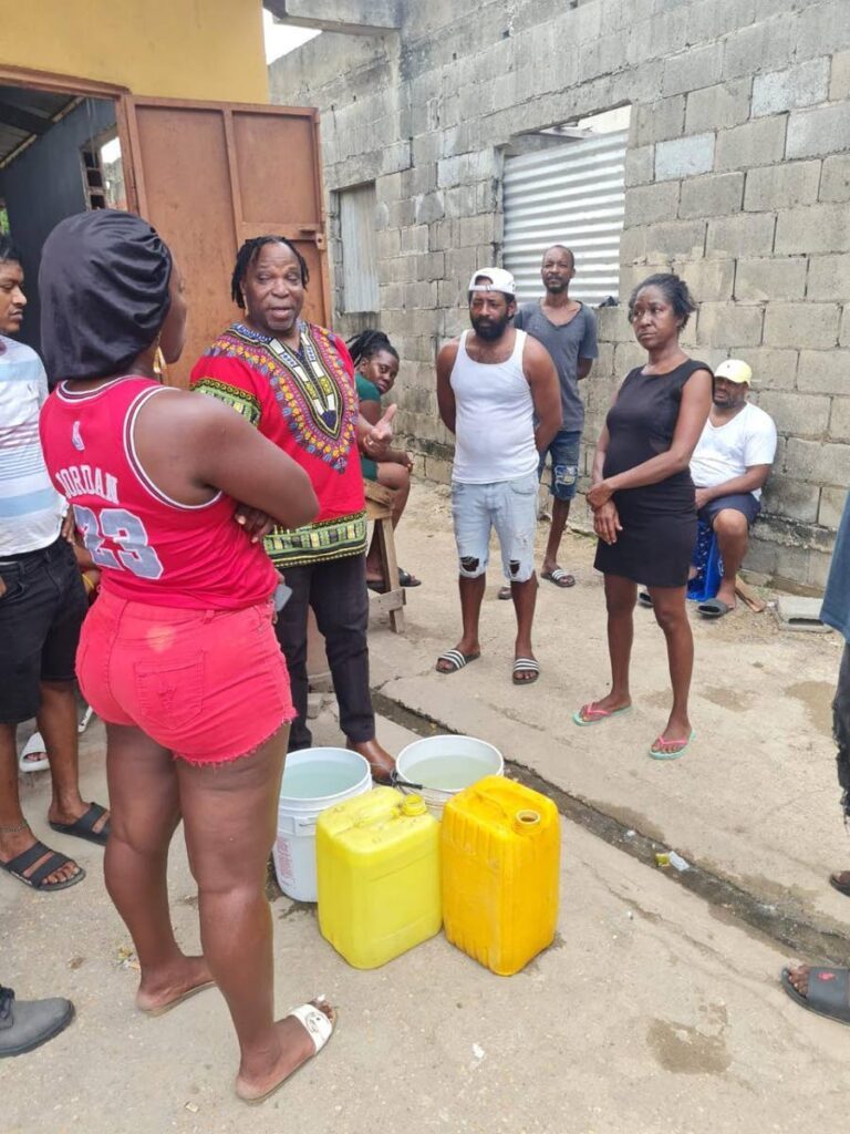 Port of Spain South MP Keith Scotland, SC, the new Minister in the Ministry of National Security, centre, speaks to residents of Sea Lots on July 27, after the police killing of Jonathan Wharwood on July 23. - 