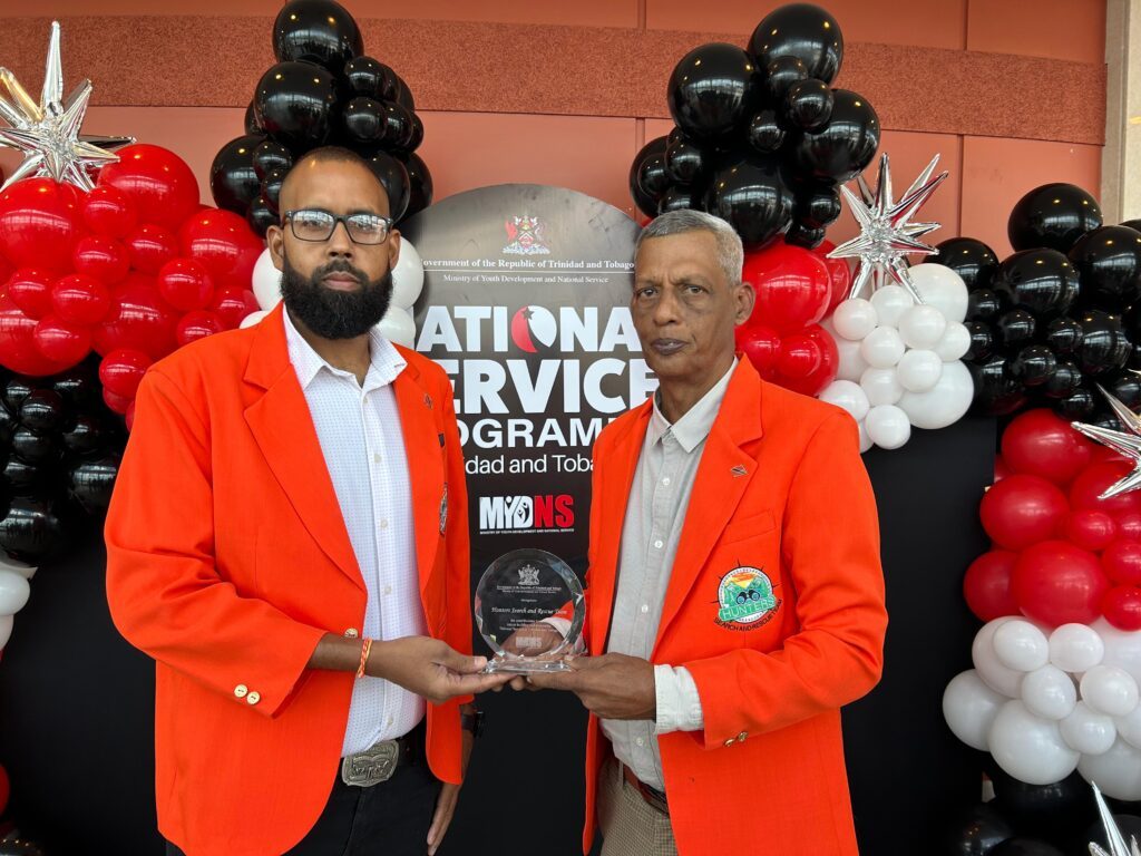 Hunters Search and Rescue Team head Vallence Rambharat (right) with member Adrian Arjoonsingh hold the award the organisation received for national service on July 30 from the Ministry of Youth Development and National Service. -