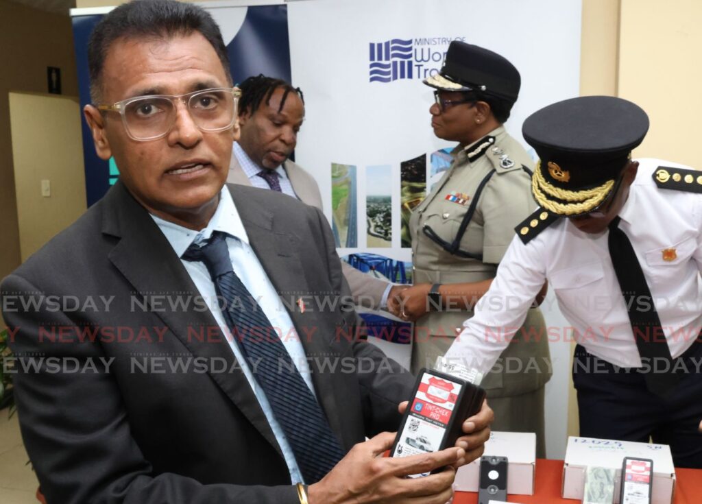 Works and Transport Minister Rohan Sinanan with a tint-measuring device, during the launch of the Windscreen and Window Tint Regulation initiative at the Ministry of National Security in Port of Spain on July 29. - Photo by Roger Jacob