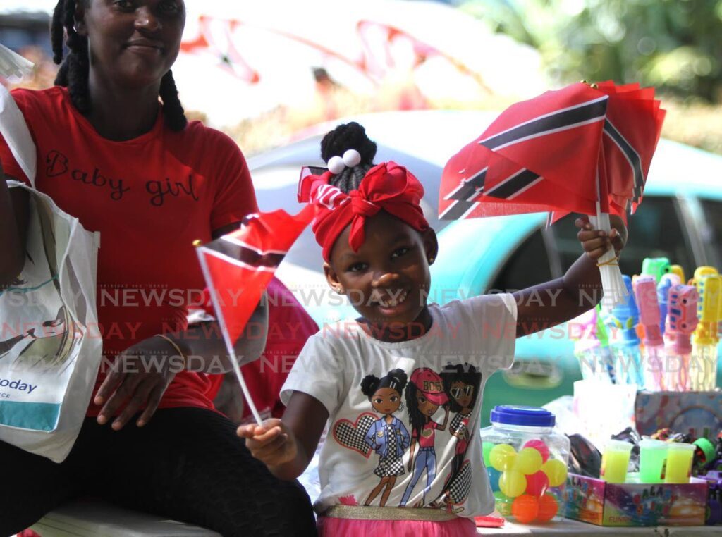 WAVE YOUR FLAG: A young spectator at the Independence Day parade waves her flag. - File photo by Ayanna Kinsale