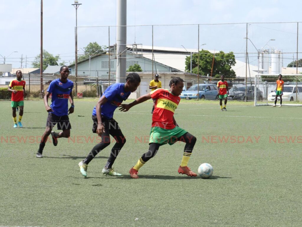 A Trendsetter Hawks player (yellow and red) tries to prevent a Pinto United player from getting the ball in an Under-17 match at the Emancipation Football Nation One-Day seven-a-side football tournament at the Marvin Lee Stadium, Macaoya on July 28.
Hawks won 4-0. - Photo by Faith Ayoung