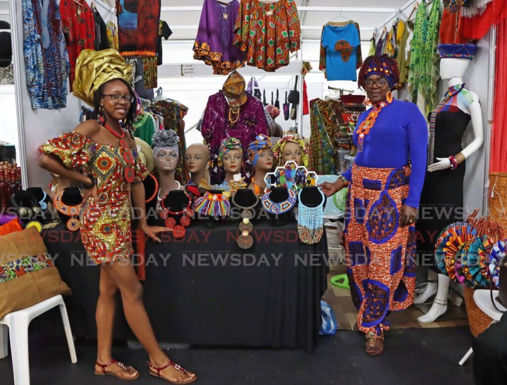 Ifeoma Mars-Skinner, left, and Kate Mars-Skinner of Malabar, Arima, pose for a photo at their booth, Aftrin Fashion, at the Emancipation Village held at the Queen's Park Savannah, Port of Spain on July 31.  - Photo by Venessa Mohammed